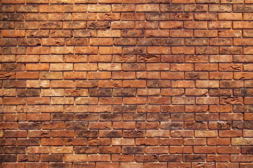 Leren behang in donkerbruine kleur aan muur met houten vloer en industriële meubels voor stoere kamer